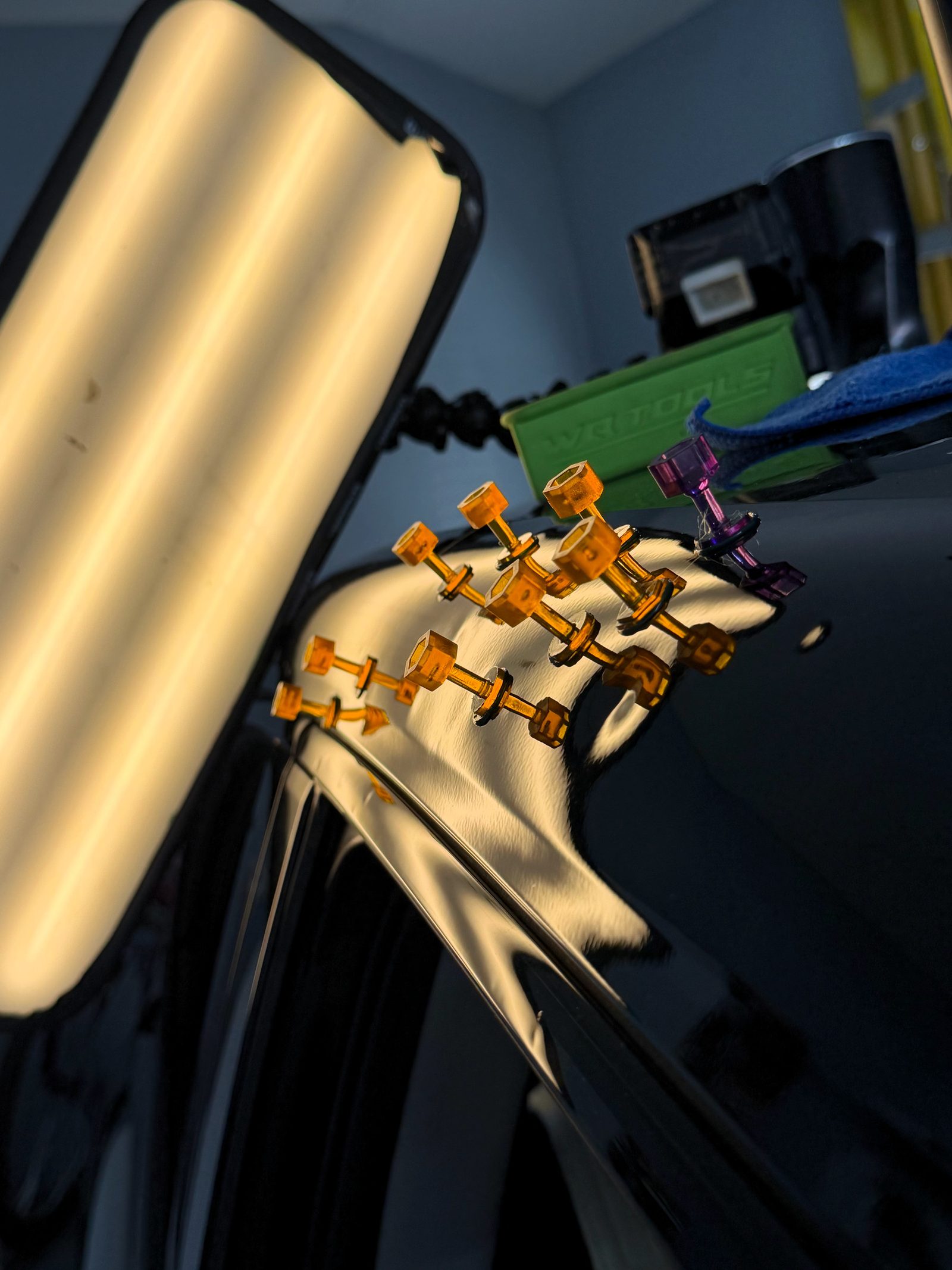Glue tabs placed for a pull repair, read in the reflection.